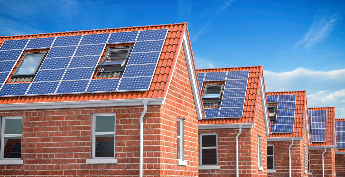 Row of house with solar panels on roof  on blue sky background.